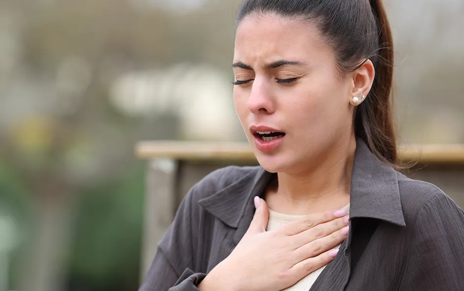 Arzt fragen starke Symptome Atemnot Eine Frau hält sich mit der einen flachen Hand die Brust