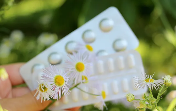 Tablettenverpackungen mit Blumenblüten davor