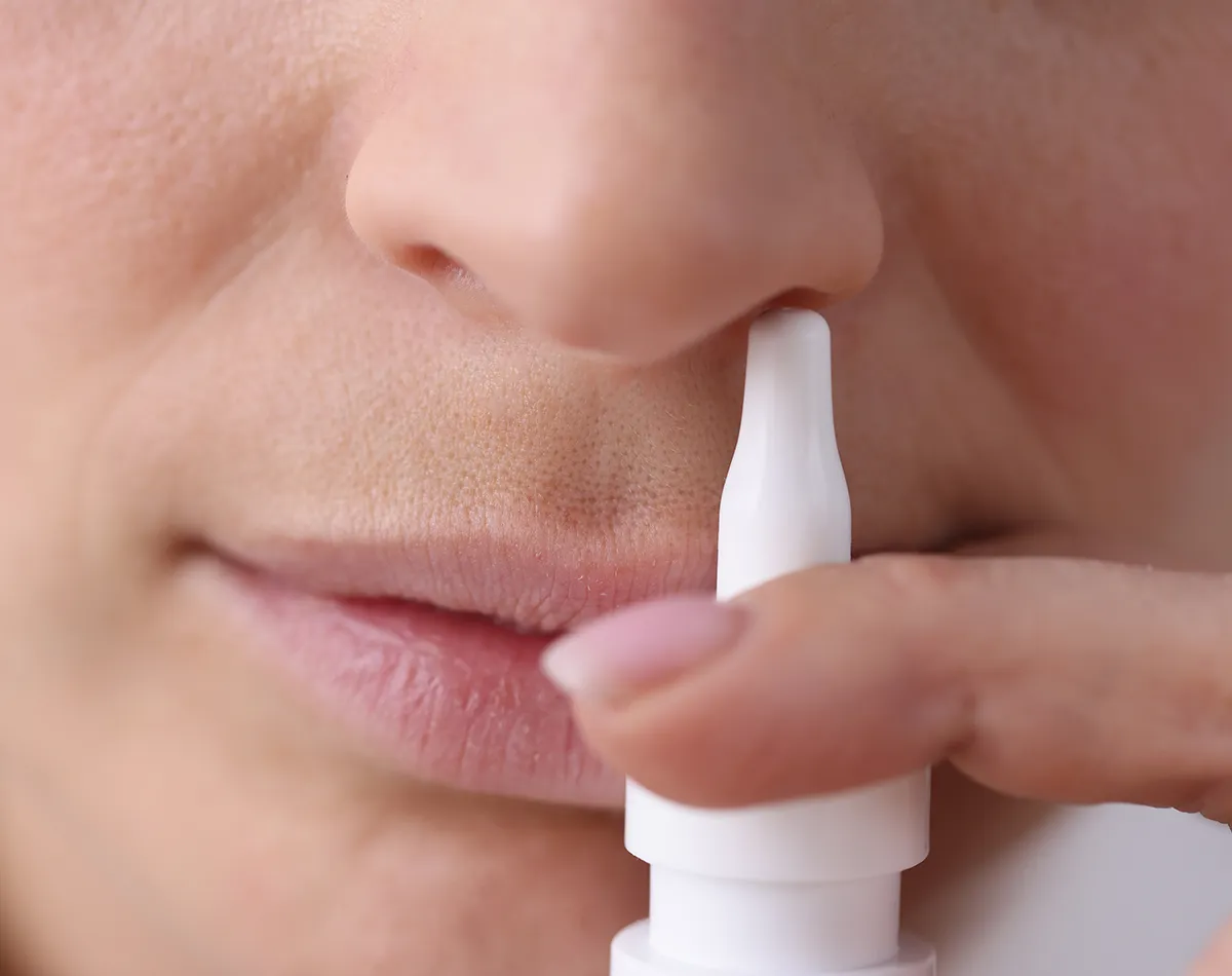 Bewährte Lösungen Pollenallergie Nasenspray vor einem Nasenloch