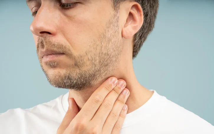 Ein Mann packt sich an den Hals