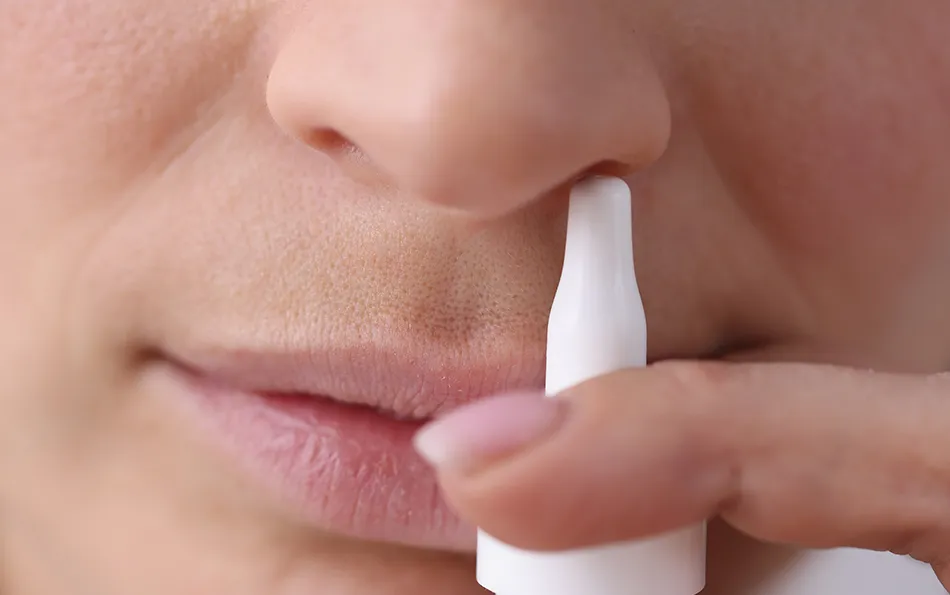 Nasenspray vor einem Nasenloch