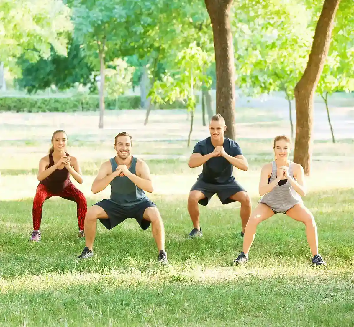 Sport im Freien Eine Gruppe führt sportliche Aktivtäten auf einer Wiese unter Bäumen aus
