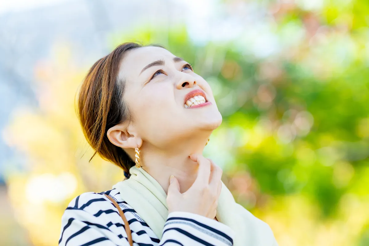 Symptom Juckreiz im Rachen Ein Frau kratzt sich am Hals