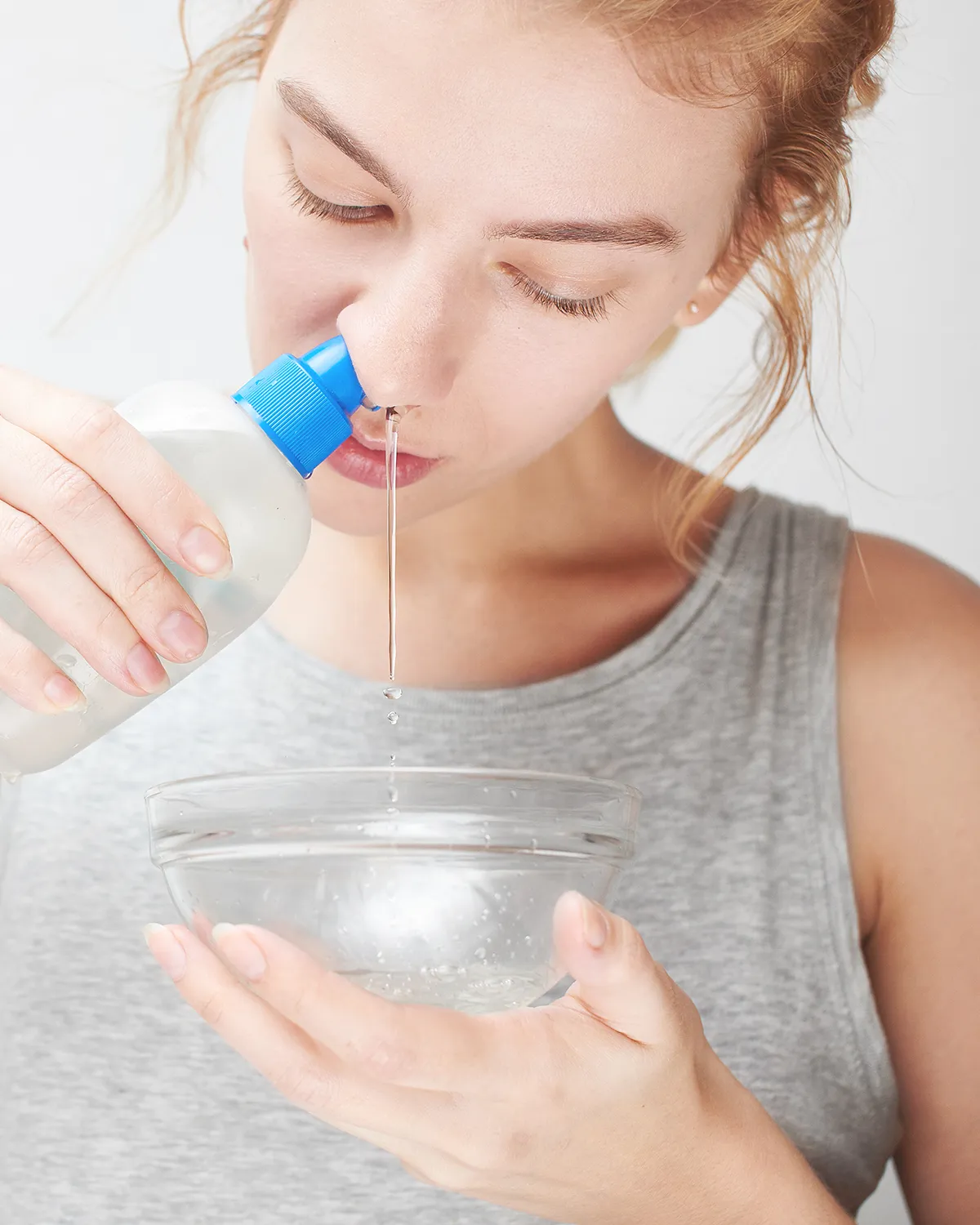 Tipps zur Linderung Nasenspühlung Ein Frau führt eine Nasendusche durch